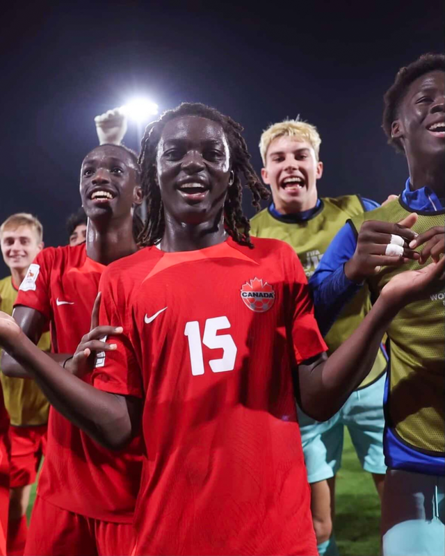 Photo of Elijah celebrating on the field with his teammates after a game
