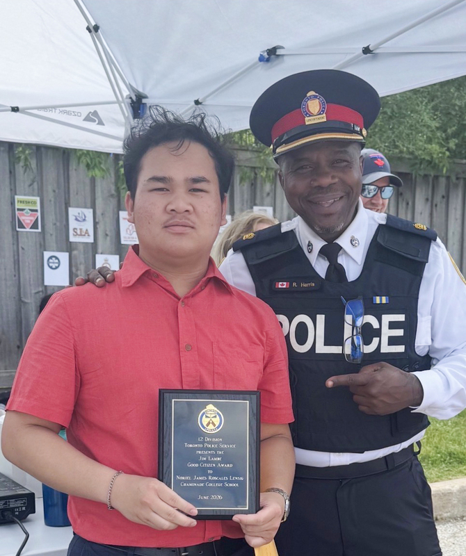 Photo of Noriel receiving his plaque from a Toronto Police Services officer