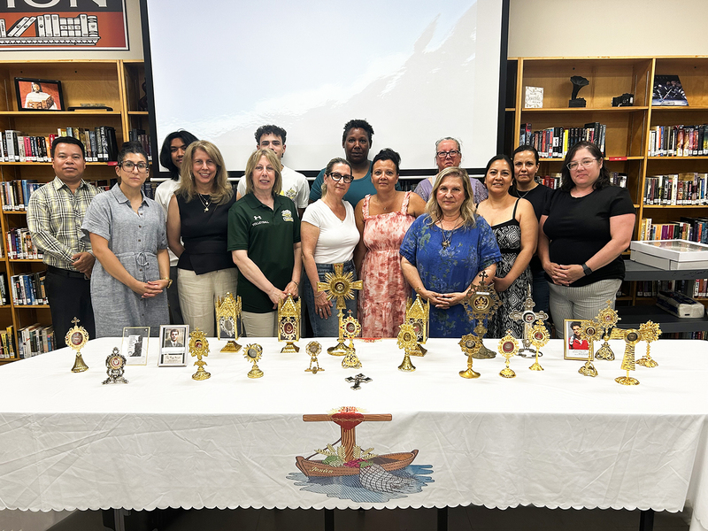 Group photo of Chaminade staff and attending with the display of sacred relics