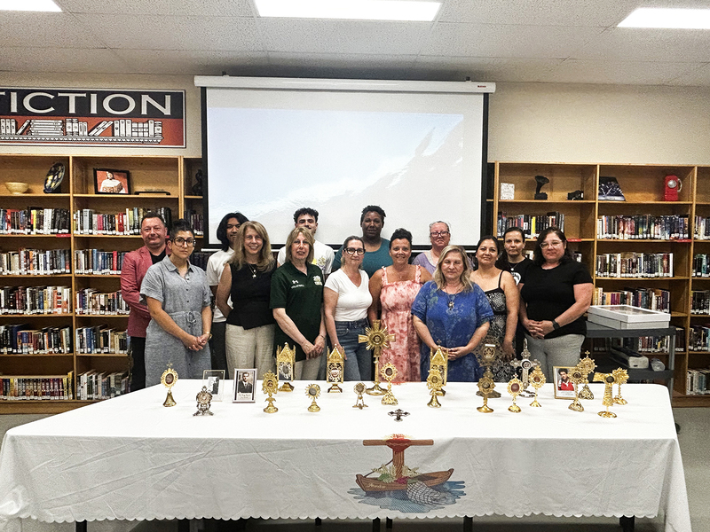 Group photo of Chaminade staff and attending with the display of sacred relics