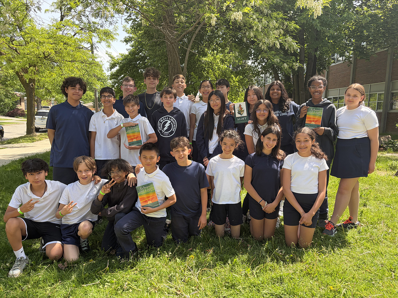 Group photo of Transfiguration students holding up copies of the book their work was published in