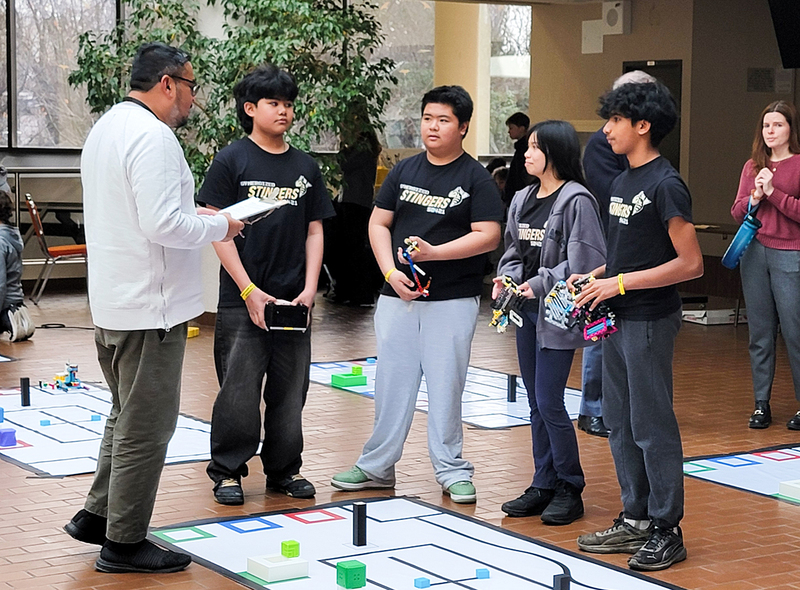 Photo of students working with their robotics during the competition