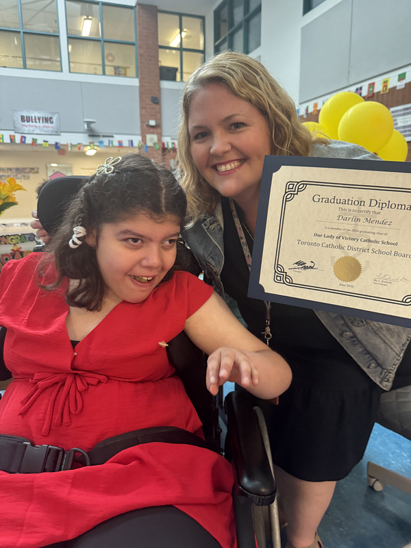 Photo of Darlin with her teacher and her diploma