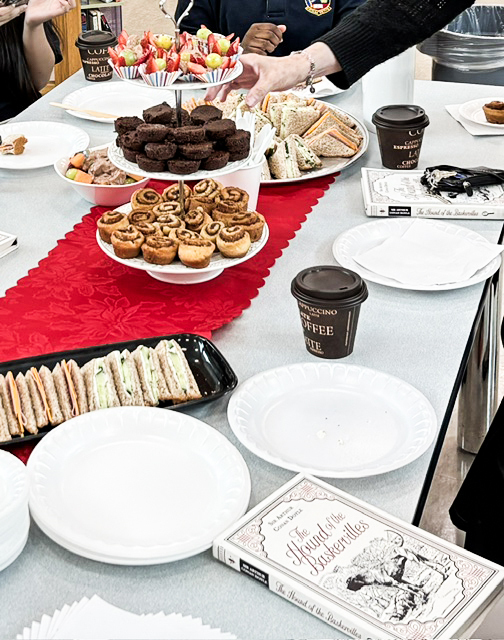 Photo of the table filled with snacks and the House of the Baskervilles book