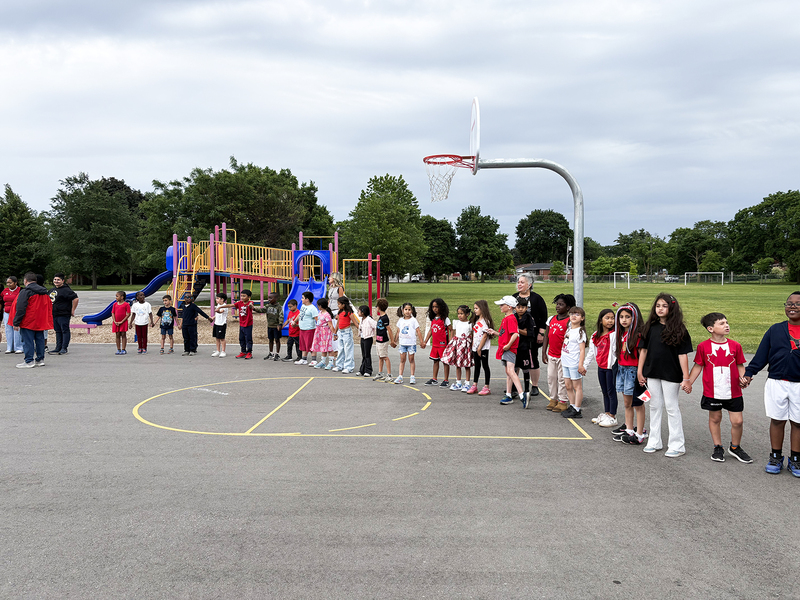 Photo of St. John Viannery students in the school grounds holding hands and wearing Canada shirts