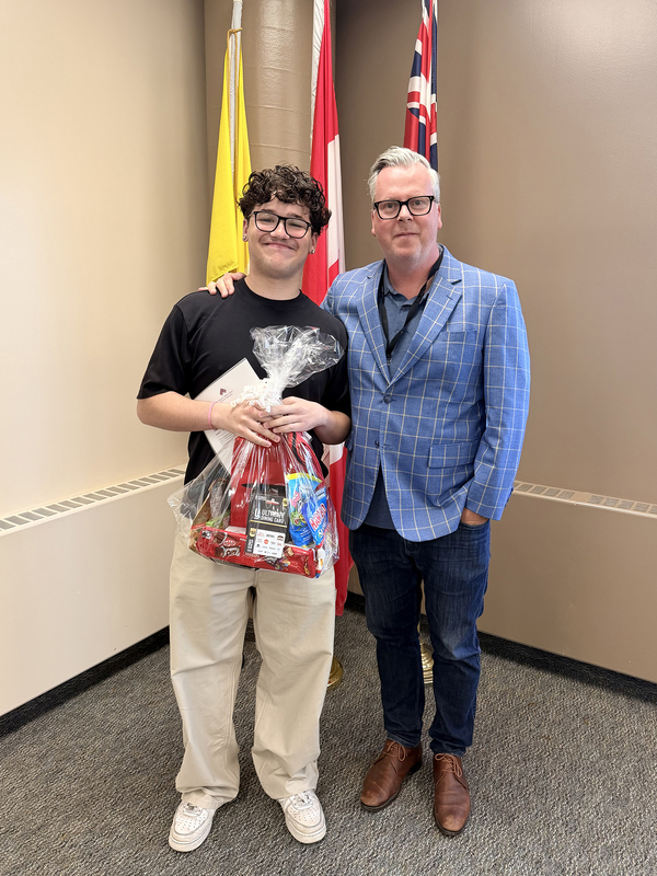 Photo of Ruben with his gift package, posing with CEO Brendan Browne