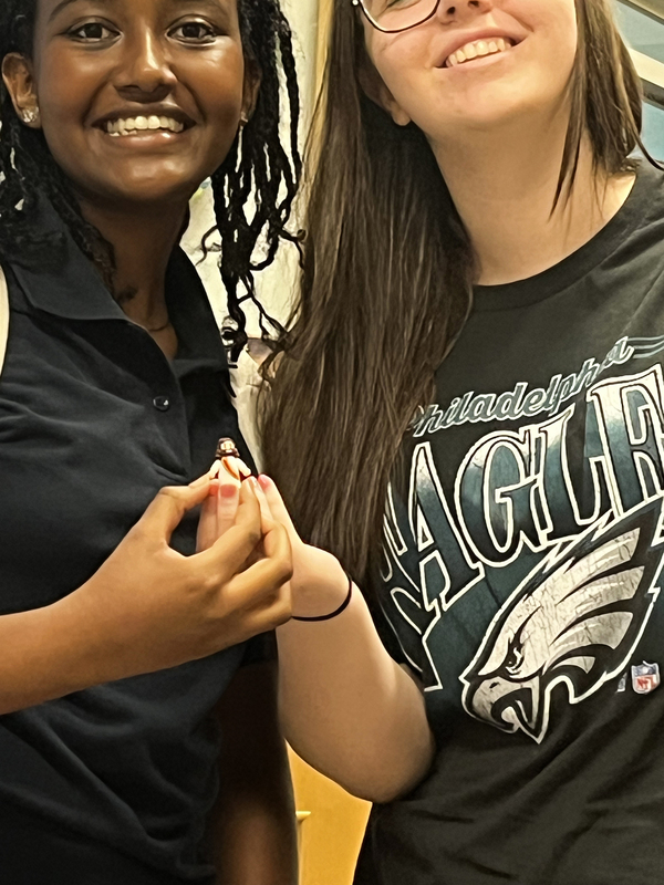 Photo of two Loretto College students holding up the mini figurine of Jesus that they found