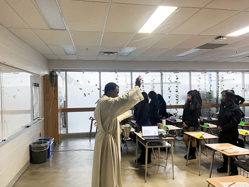Photo of Father Joseph visiting one of the Loretto College classrooms and the students standing up to listen to him