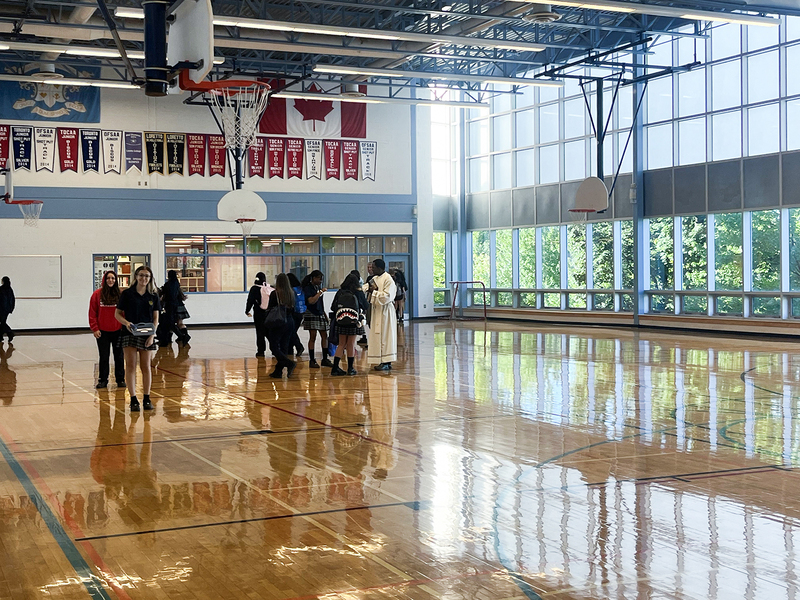 Photo of Father Joseph speaking with the students in the Loretto College gymnasium