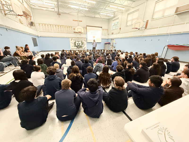 Photo of St. John Bosco students listening to Jason speak during the visit