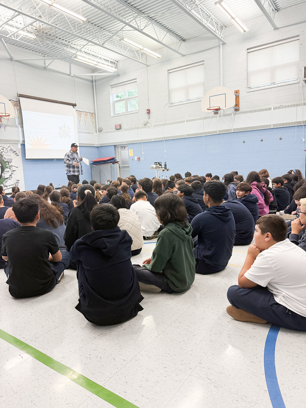 Photo of St. John Bosco students listening to Jason speak during the visit