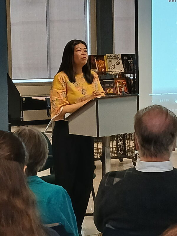 a woman speaking at a podium in front of an audience