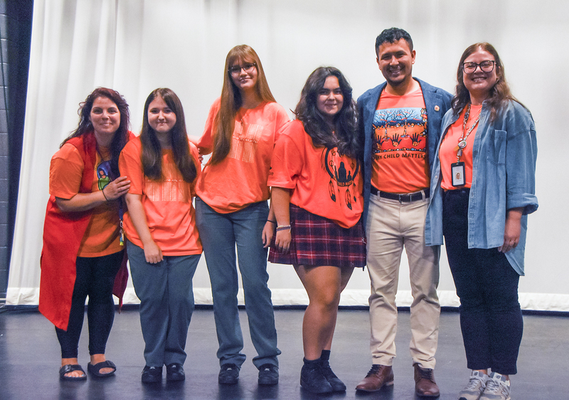 Photo of Redmond students and staff posing with Jason, all of them in Orange shirts