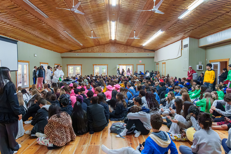 Photo of students listening to the camp facilitators during an assembly at Camp Muskoka