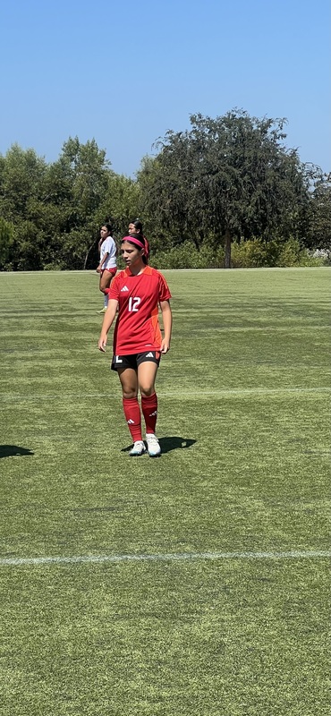 Photo of Olivia on the coat in her red jersey with the number 12 on it in white