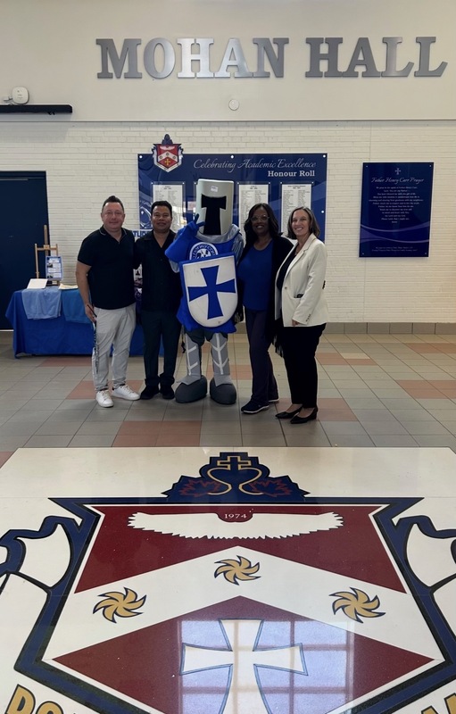Photo of FHC staff members posing with the Crusader knight mascot