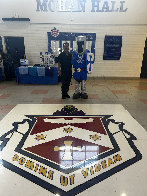 Photo of an FHC staff member posing with the Crusader knight mascot
