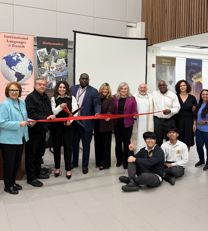 Photo of Dante staff and students at the opening and blessing gathered around the red ribbon, accompanied by TCDSB senior staff, the pastor and other attendees.