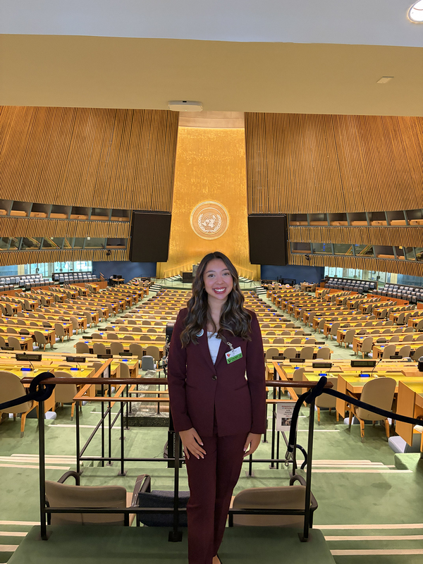 Photo of Sofia posing with the assembly hall sprawled out behind her