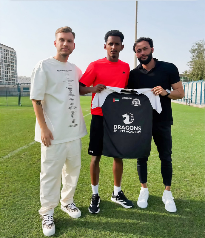 Photo of Samir on the field holding his Dragons jersey