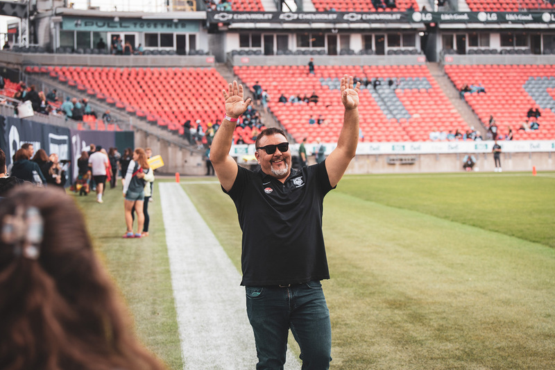 Photo of Coach Vescio on the field waving to people
