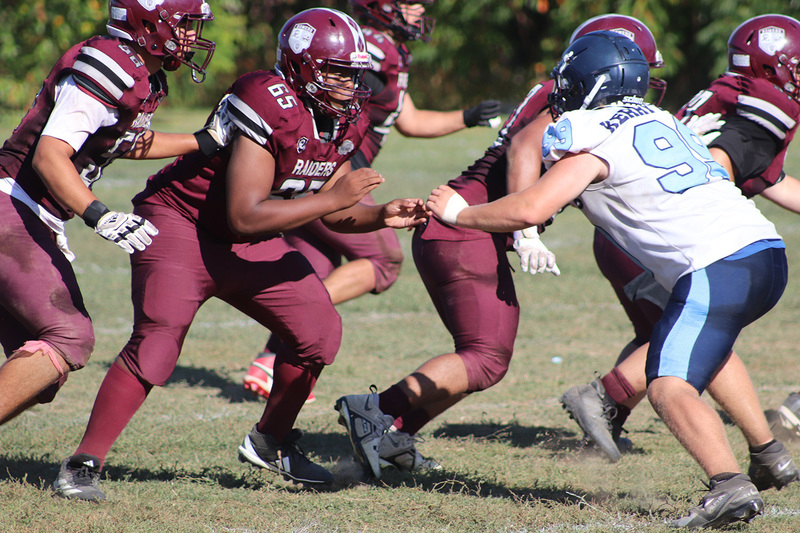 Photo of Romero and opposing team football players on the field during the game