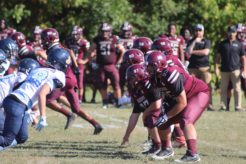 Photo of Romero and opposing team football players on the field during the game