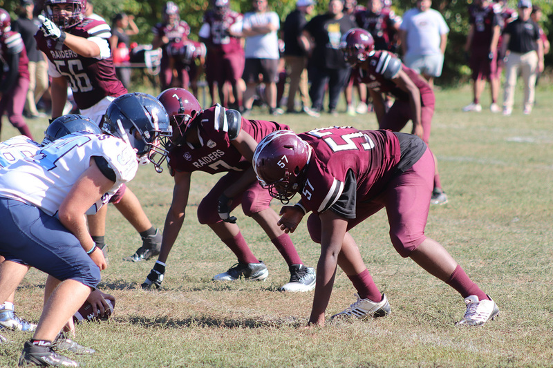 Photo of Romero and opposing team football players on the field during the game