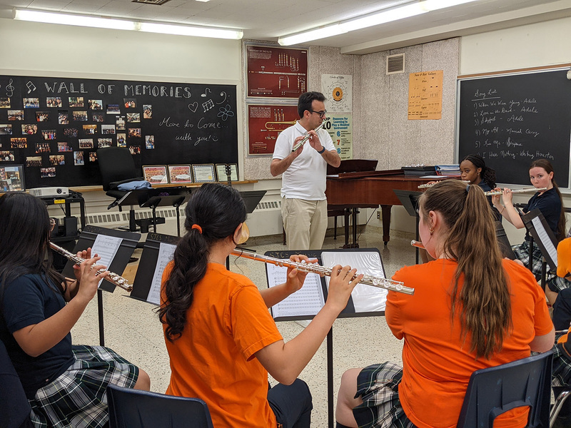 Photo of SJCS students playing the flute while being coached by Dr. Gomes
