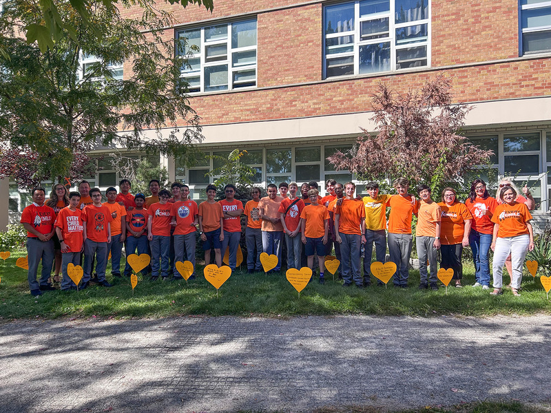 Group photo of Chaminade College School students and staff standing together in their orange shirts