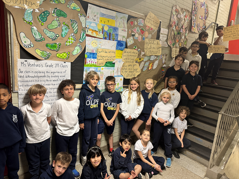 Group photo of OLPH Grade 2/3 class students with their creative work