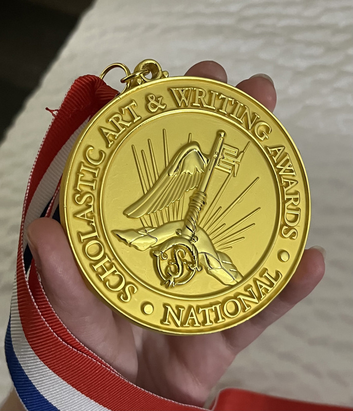 Closeup photo of Diana's hand holding her gold medal