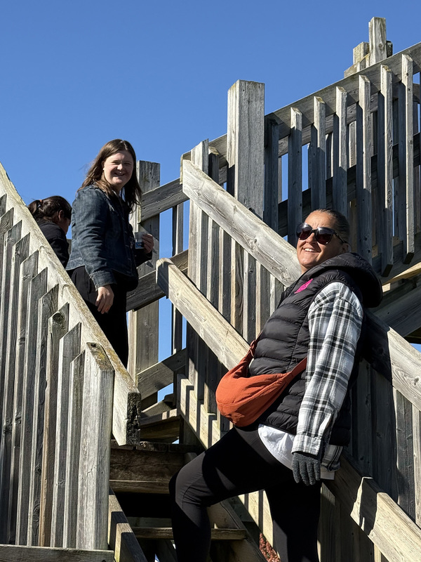 Photo of a student and a staff member going up the wooden stairs