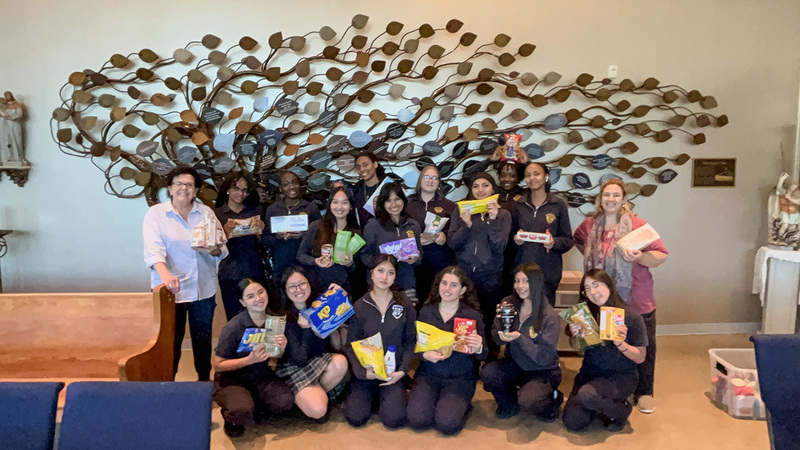 Group photo of Loretto students and staff with the food items collected and donated
