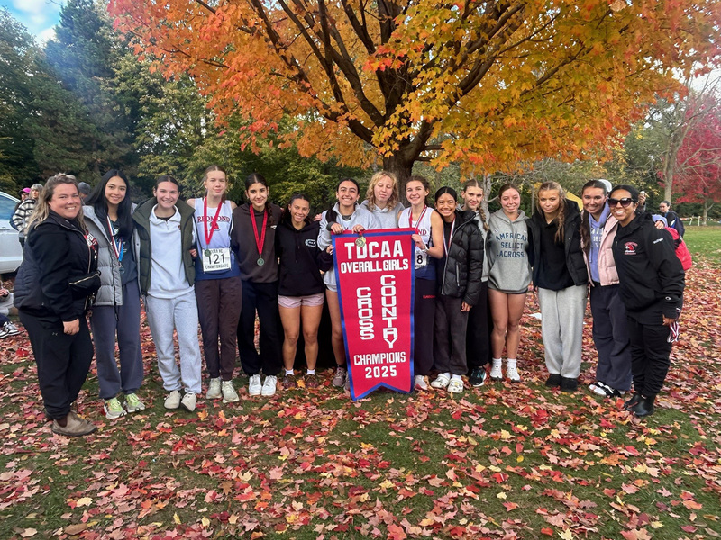 Group photo of the Father John Redmond cross country team with their TDCAA Overall Girls Championship banner