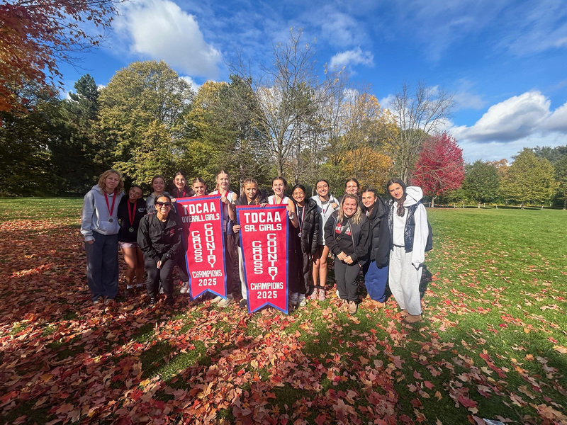 Group photo of the Father John Redmond cross country team with their TDCAA Overall Girls and Senior Girls championship banners