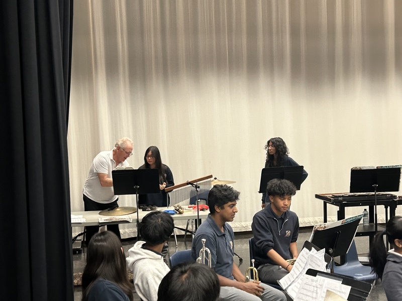 A music teacher assisting a student