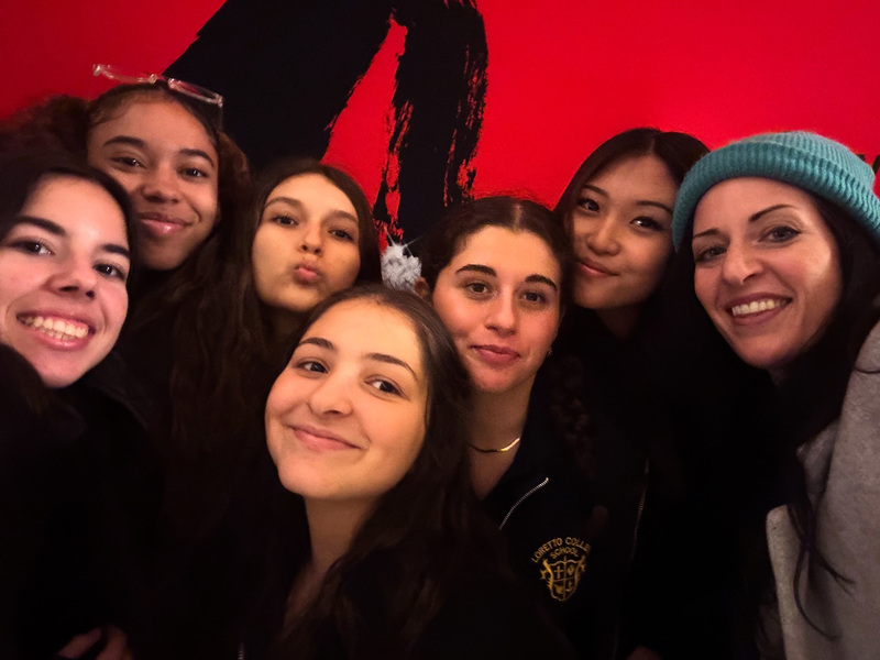 Group photo of Loretto College School students and staff in front of a poster for MJ the Musical