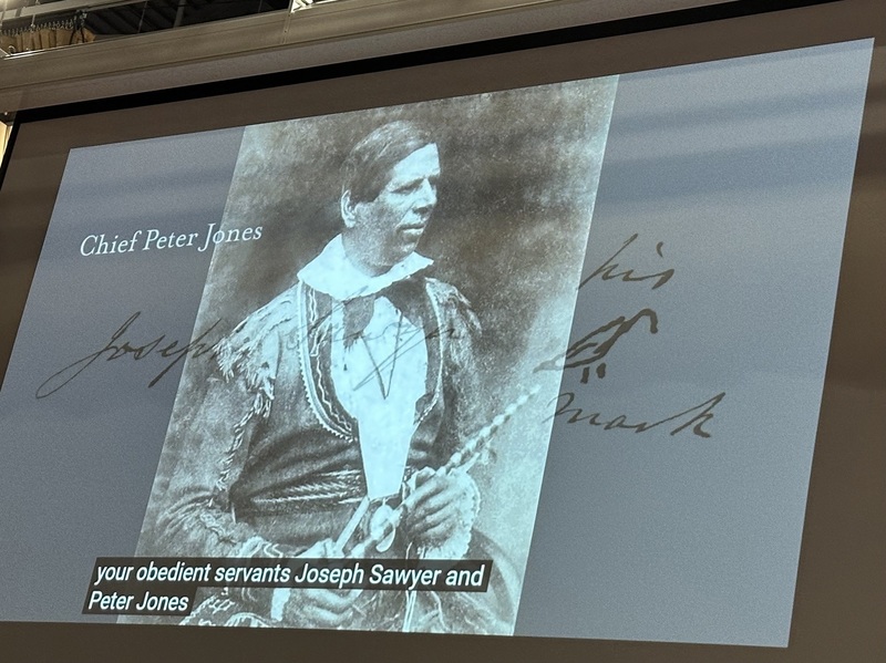 Photo of the presentation at the event showing a photo of Chief Peter Jones on the screen