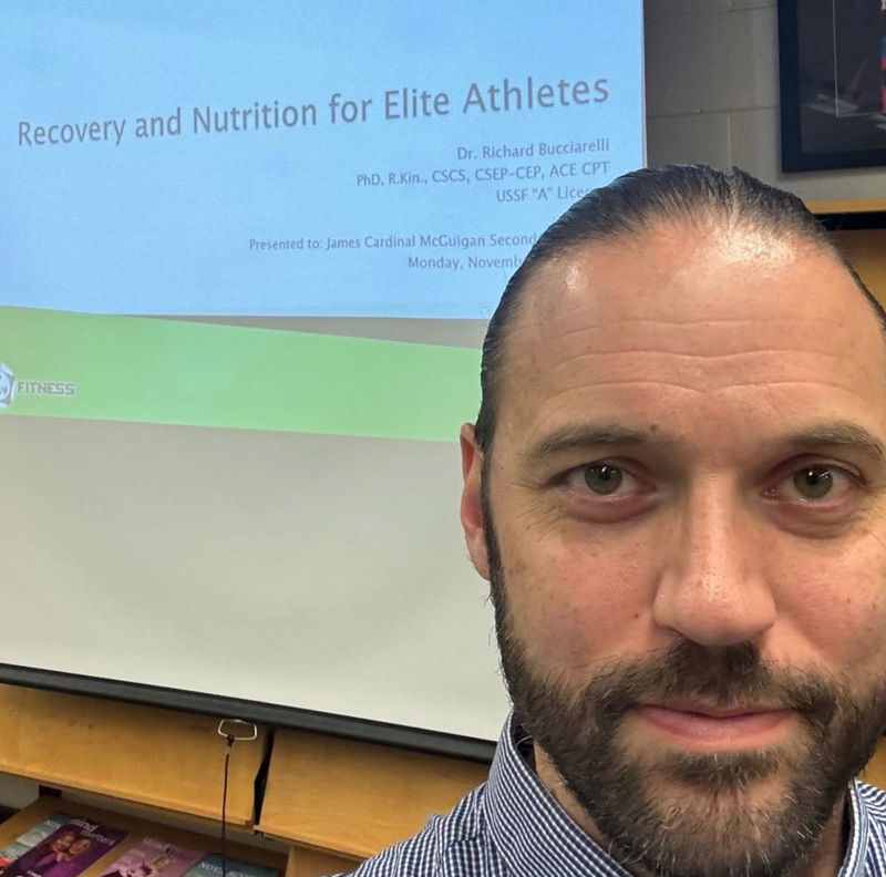 Closeup photo of Dr. Richard Bucciarelli's face in front of his presentation screen