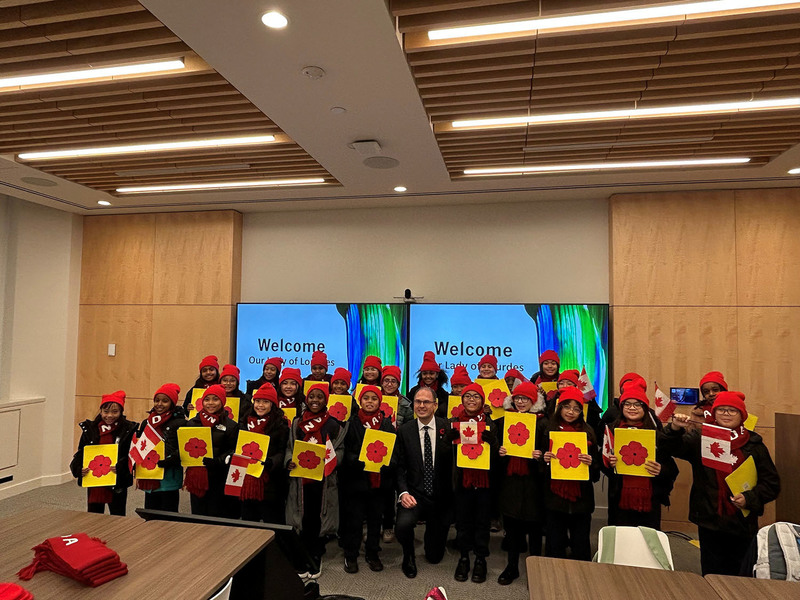 Group photo of Our Lady of Lourdes students with poppy props
