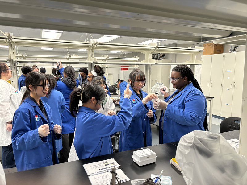 Photo of SJOA students working in a Toronto Metropolitan University (TMU) lab with the help of TMU students during the event