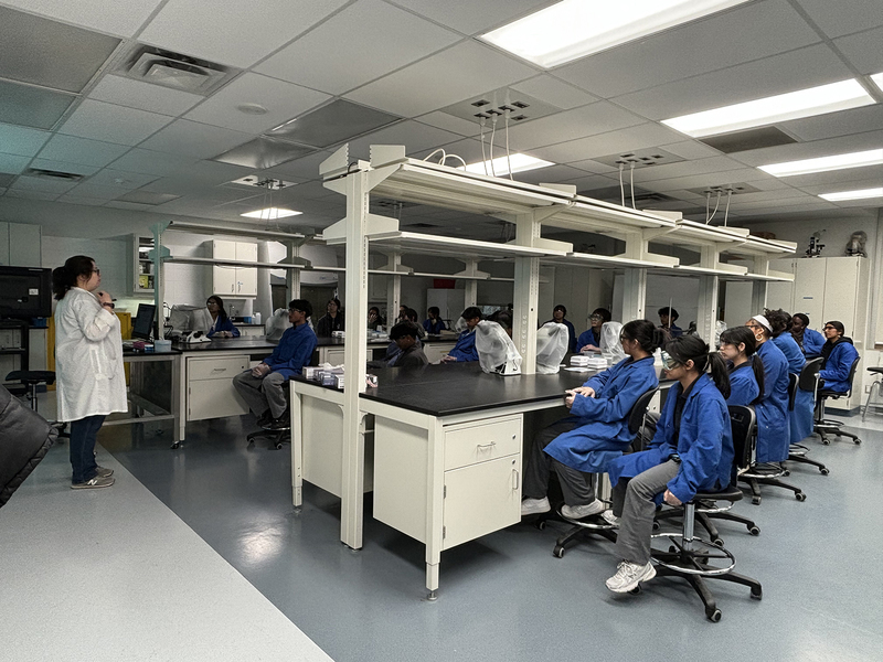Photo of SJOA students working in a Toronto Metropolitan University (TMU) lab with the help of TMU students during the event