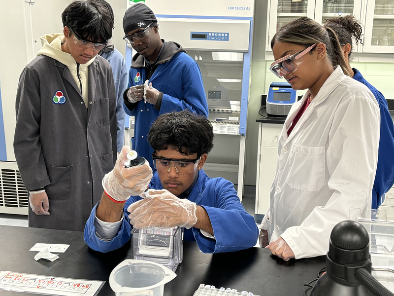 Photo of SJOA students working in a Toronto Metropolitan University (TMU) lab with the help of TMU students during the event