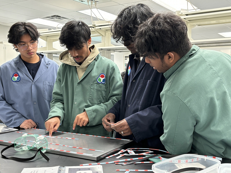 Photo of SJOA students working in a Toronto Metropolitan University (TMU) lab with the help of TMU students during the event