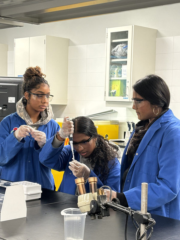 Photo of SJOA students working in a Toronto Metropolitan University (TMU) lab with the help of TMU students during the event