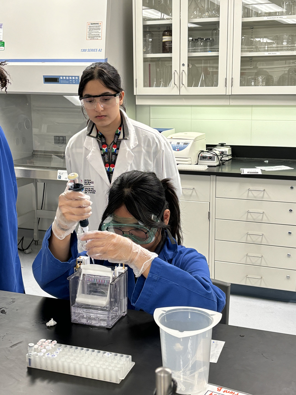 Photo of SJOA students working in a Toronto Metropolitan University (TMU) lab with the help of TMU students during the event