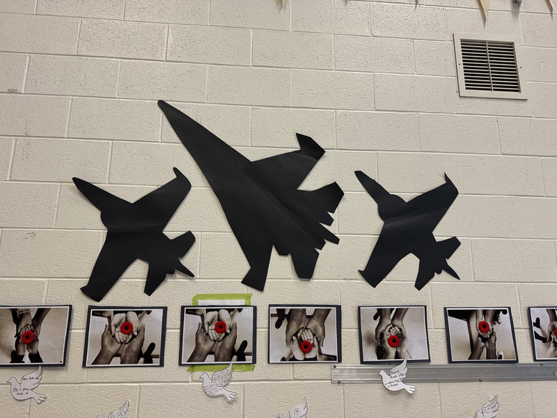 Photo of artwork by students of fighter planes and photos of students holding poppies