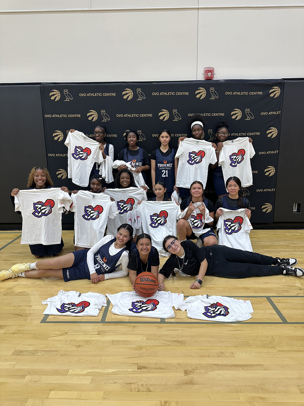 Group photo of Madonna varsity basketball team members holding up their new Raptors t-shirts