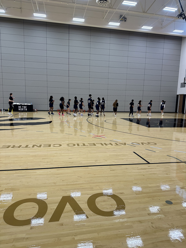 Photo of Madonna varsity basketball team members drilling on the OVO court